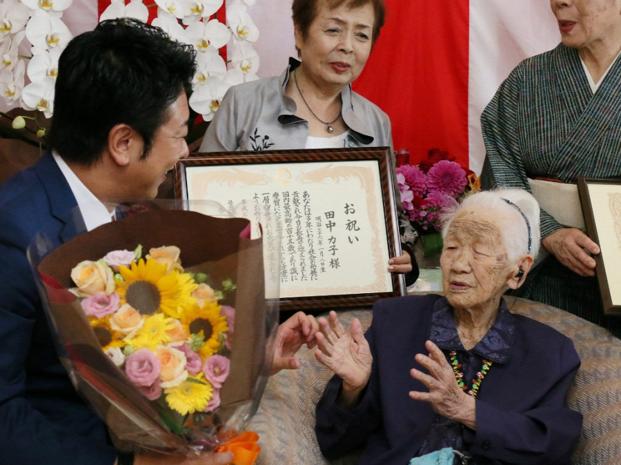 Японка Кане Танака народилася 2 січня 1903 року. Того ж року перешою серед жінок Нобелівську премію отримала Марі Кюрі, а брати Райт здійснили свій перший пілотований політ.
