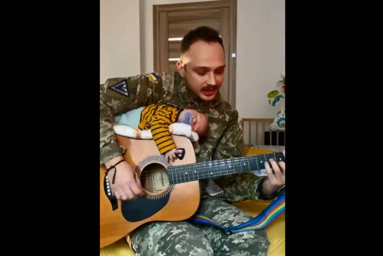 Військовий грає колискову немовляті.