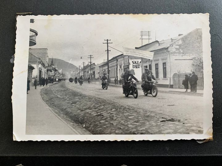 На чорно-білому фото мотоциклісти проїжджають однією з вулиць Виноградова приблизно 60 років тому.
